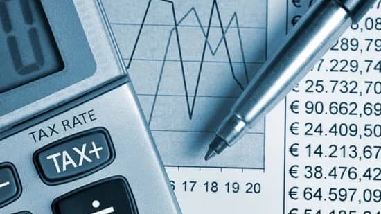 Taschenrechner mit der Aufschrift Tax auf einer Steuertabelle